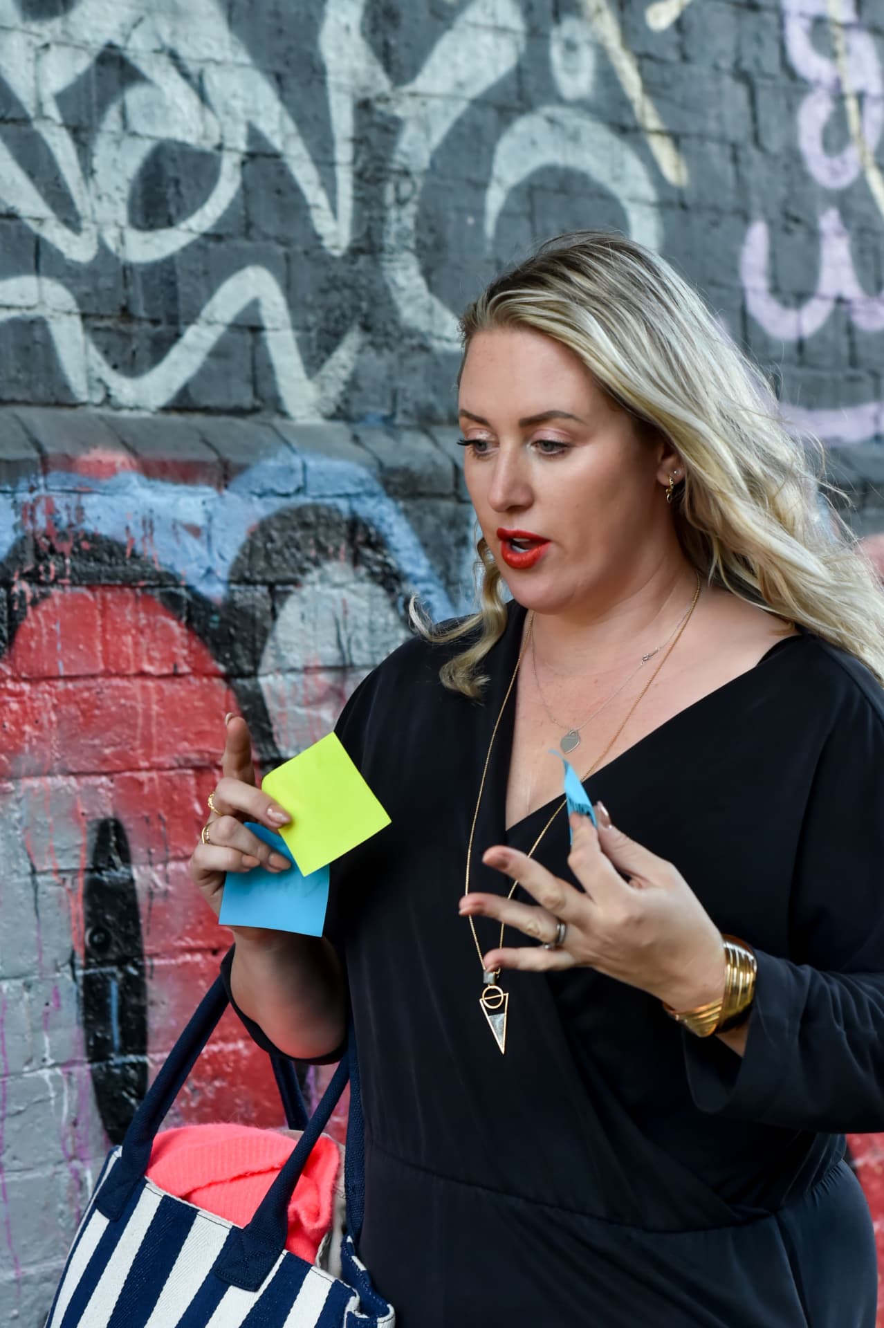 Emma Fishlock mid-explanation, holding sticky notes during a coaching session.